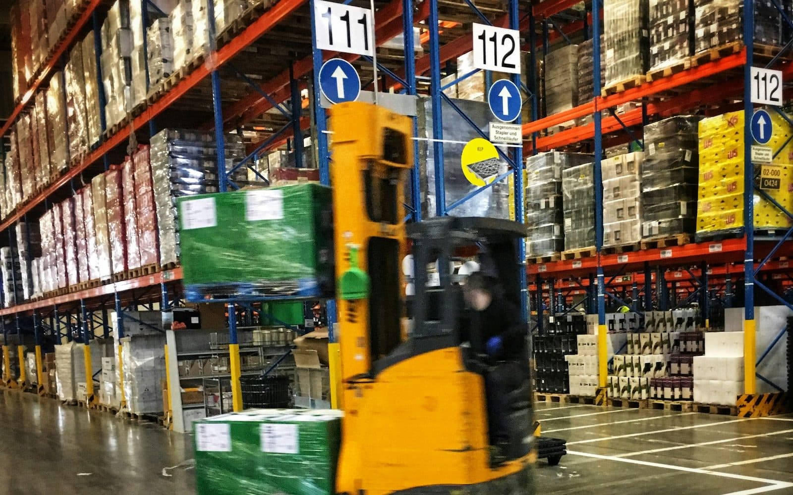 Chariot élévateur en manœuvre dans un entrepôt logistique à rayonnages